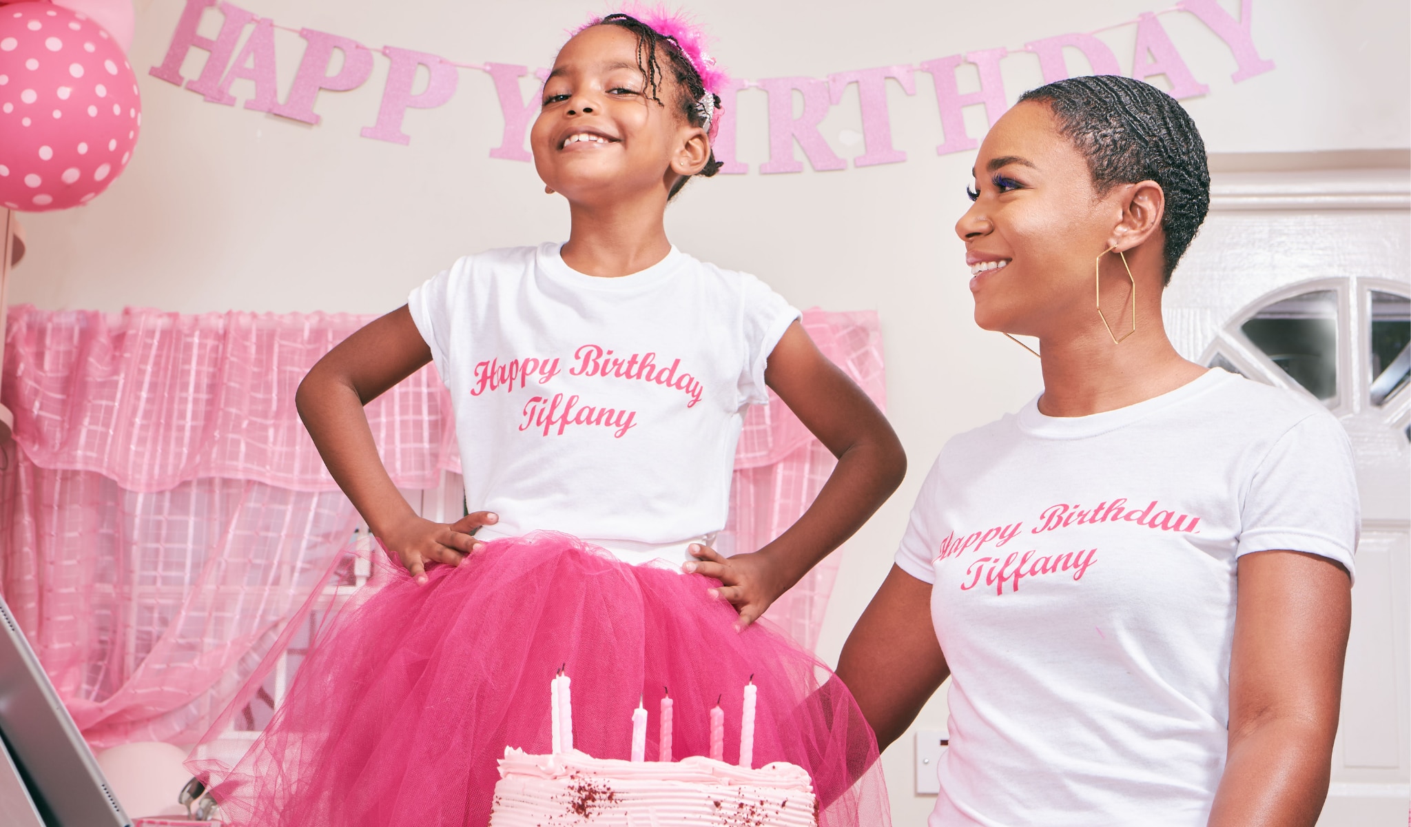 african american mother and daughter smiling with cake